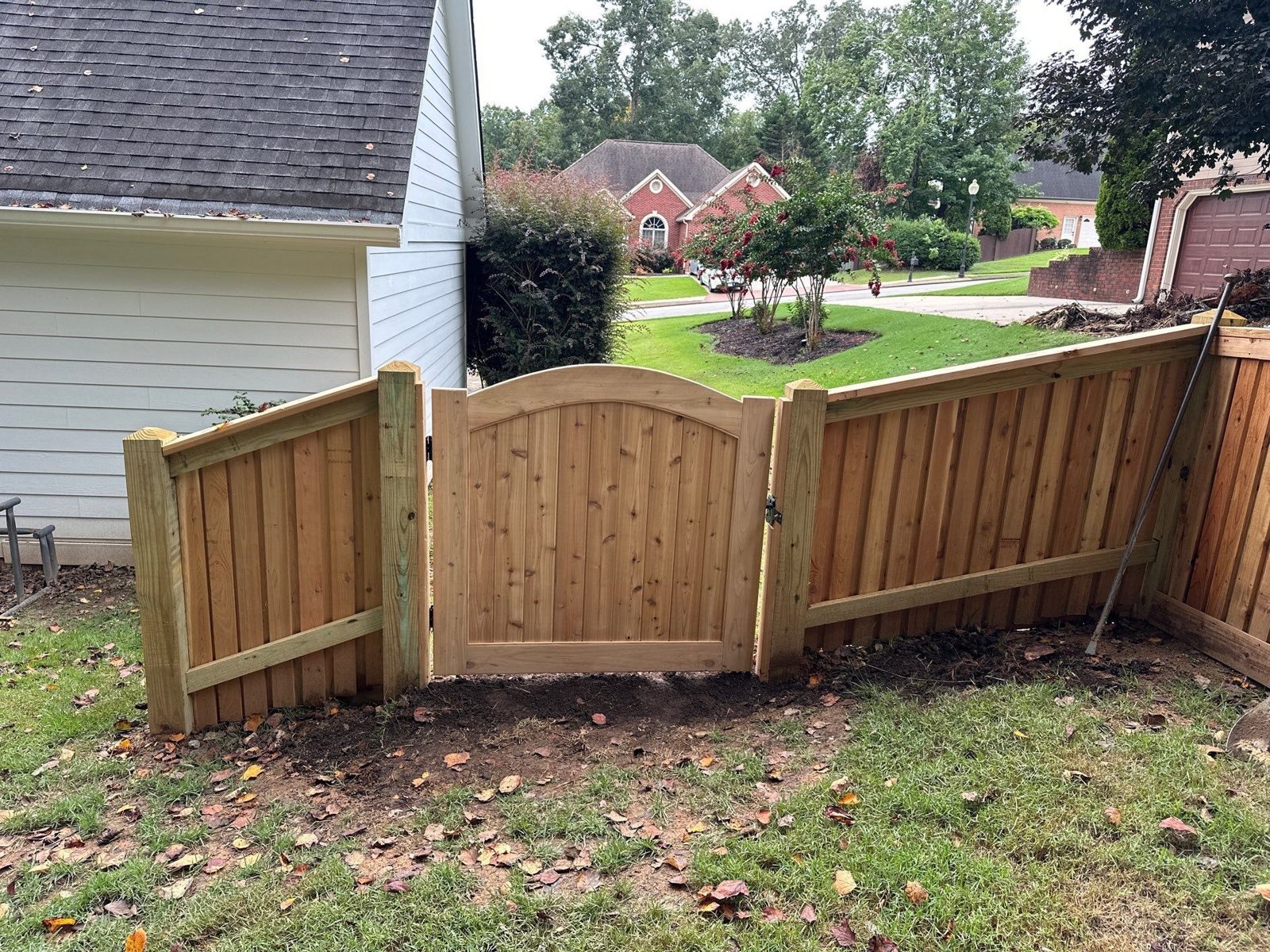 Wood privacy fence with arched double gate