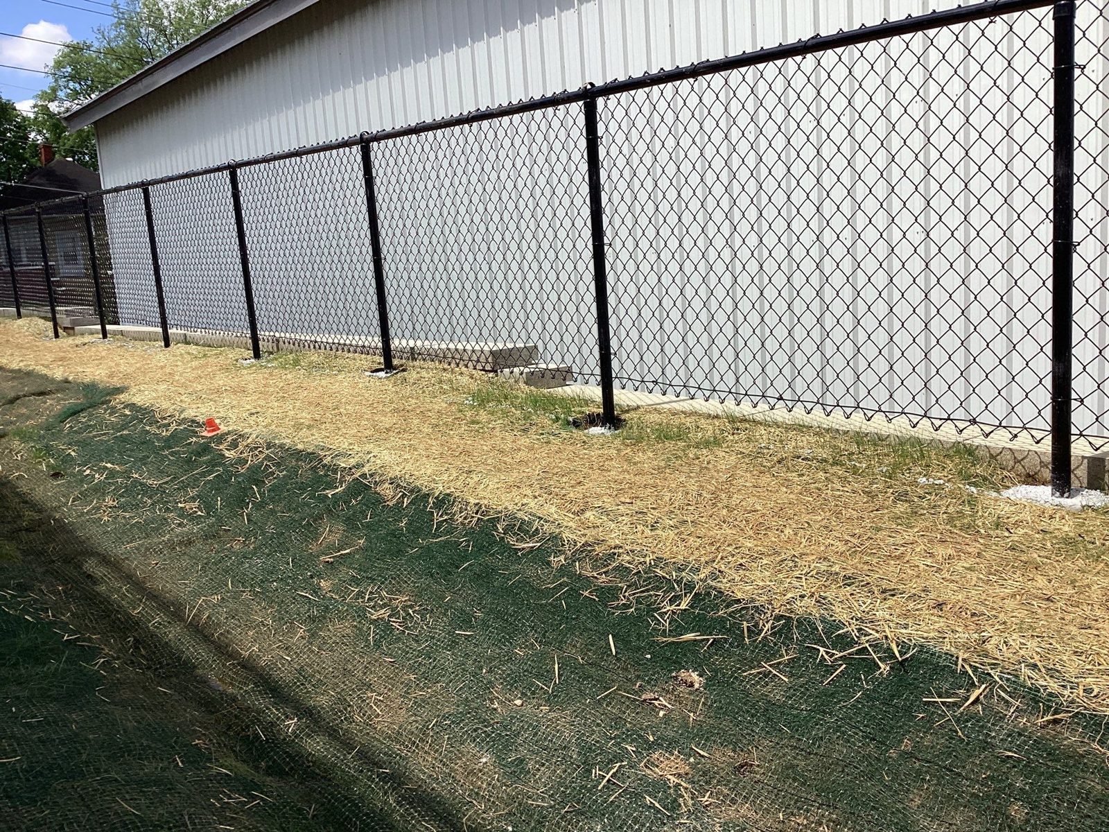 Black vinyl-coated chain link along a commercial building