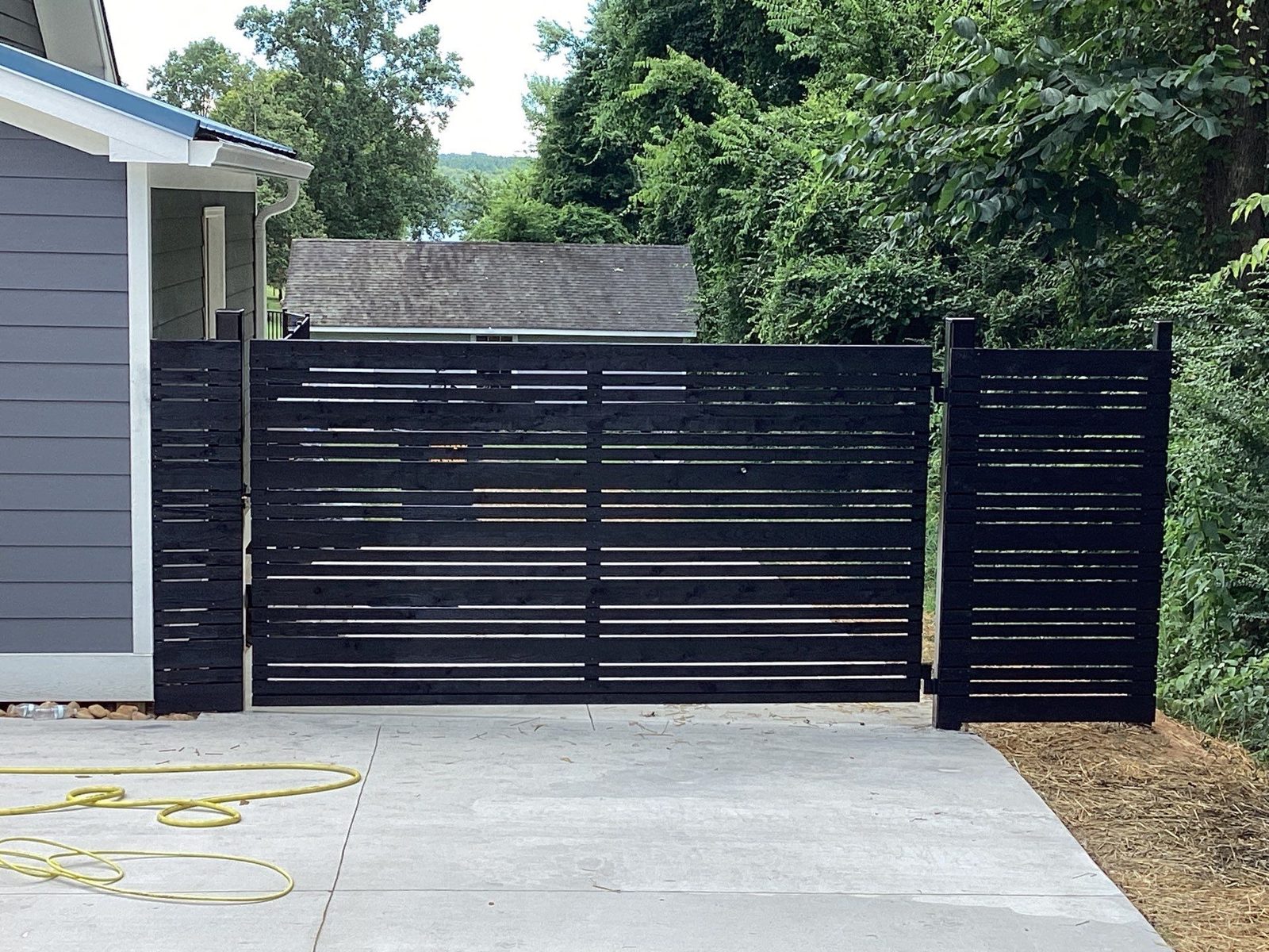Black horizontal-slat driveway gate